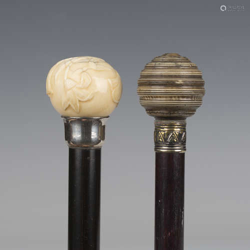 An Edwardian ebonized walking cane, the ivory handle carved ...