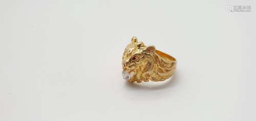 18K黄金戒指（千分之七百五十），代表一只狮子的头颅，口中衔着一颗白...