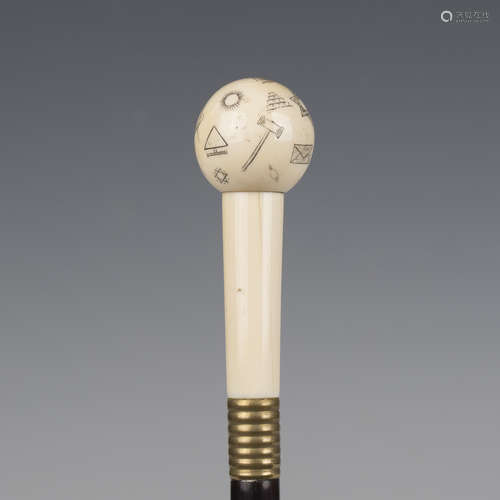 An early 20th century ebonized walking cane, the ivory handl...