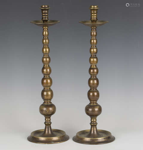 A pair of 20th century patinated brass candlesticks of turne...