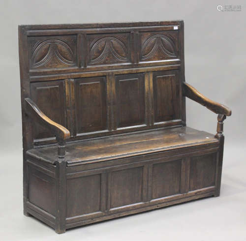 An 18th century provincial oak panelled box seat settle, the...