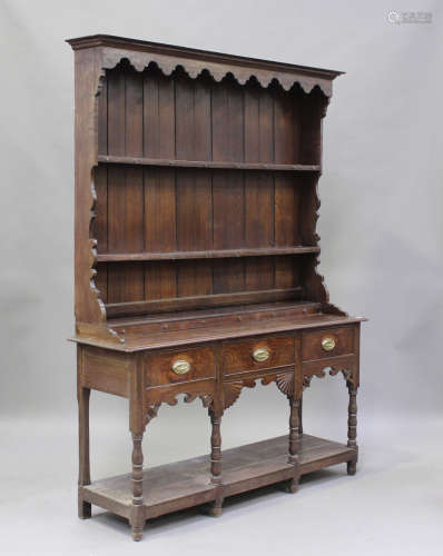 A late Victorian oak dresser, the shelf back above six dummy...