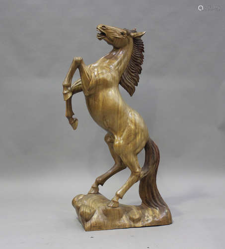 A large late 20th century carved hardwood model of a rearing...