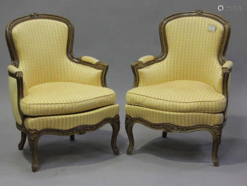 A pair of 20th century French beech showframe fauteuil armch...