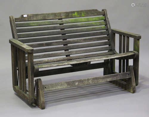 A late 20th century slatted hardwood rocking garden bench, h...