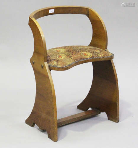 An Art Deco walnut dressing table stool, the seat covered in...