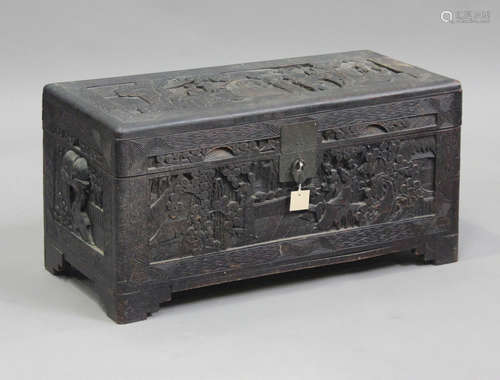 A Chinese camphor trunk, carved in relief with figures in la...