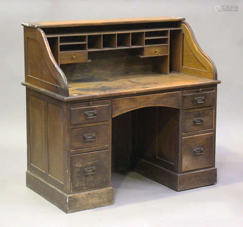 An Edwardian oak roll-top desk, the tambour front above seve...