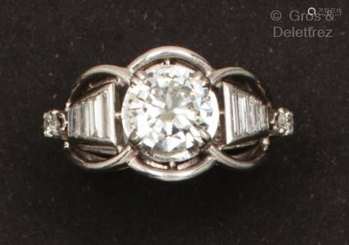 一枚白金和铂金戒指，交错镶嵌着一颗明亮式切割钻石和长方形钻石。...