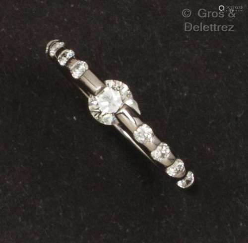 白金戒指，镶嵌着一颗移动式明亮型切割钻石和较小的钻石。手指大小...