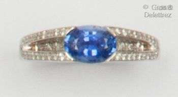 白金戒指，镶嵌着一颗椭圆形蓝宝石和几行明亮式切割钻石。手指大小...