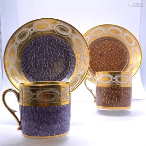 巴黎的瓷器一对瓷杯和它们的茶碟，一个有棕色的卵石装饰，另一个有...