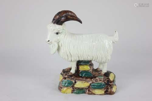 A glazed pottery model of a goat possibly Irish, standing on...