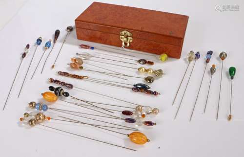 A collection of hat pins housed in a wooden box.