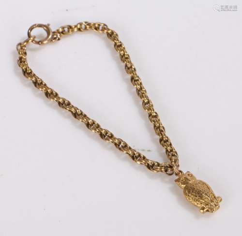 9 carat gold owl charm, attached to a yellow metal chain, gr...