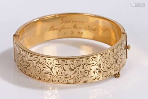 Gold plated bangle, the body with scroll and foliate decorat...