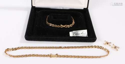 Yellow metal necklace, bracelet and earring set housed in a ...