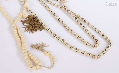 Two strings of bone prayer beads, one with skeleton faces (2...