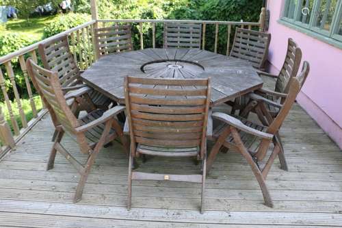 Large garden table and eight chairs, the angled table with u...