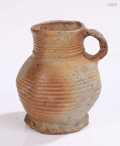 14th/15th Century stoneware jug, having a ribbed bulbous bod...