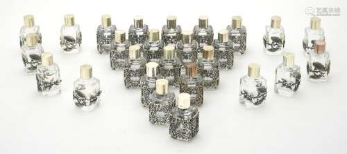 Twenty six glass scent bottles with silver coloured mounts