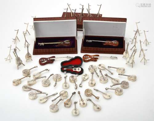 A collection of silver stringed musical instrument pendant b...