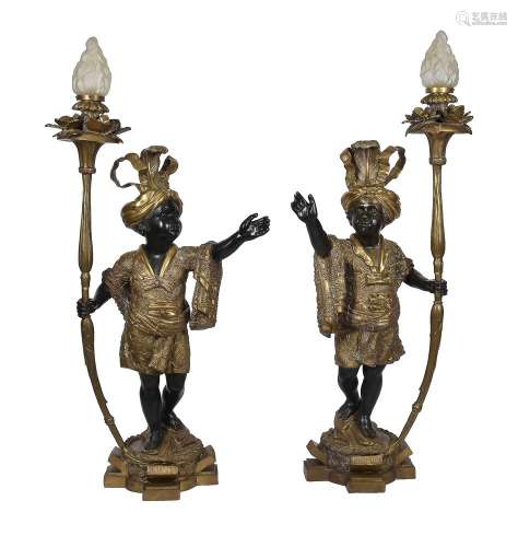 A pair of patinated and parcel gilt metal blackamoor figural...
