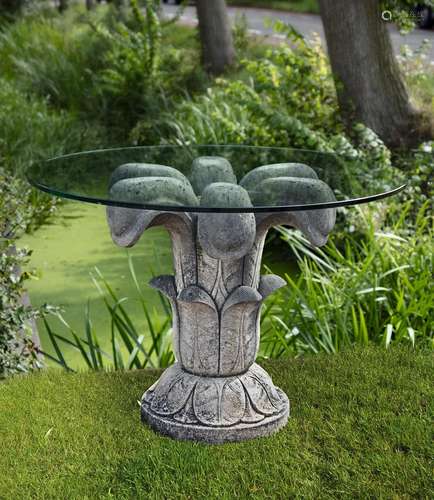 A carved limestone and glassed topped table