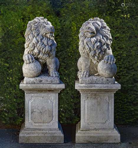 A pair of sculpted limestone models of lions on pedestals