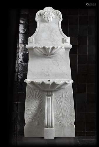 A sculpted white marble wall fountain