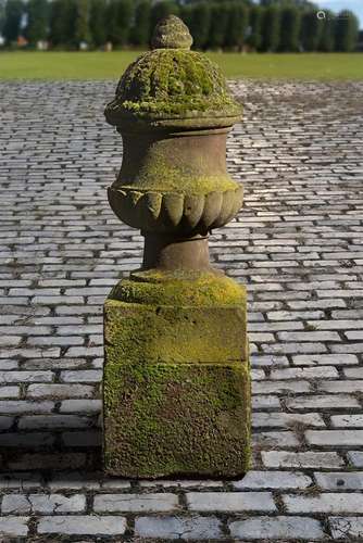 A carved red sandstone urn-on-plinth