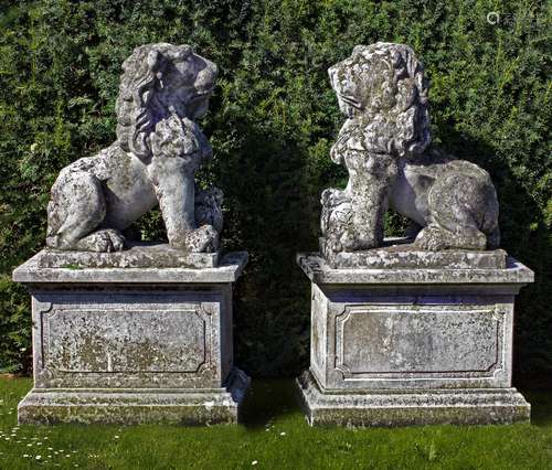 A pair of sculpted limestone models of lions on pedestals