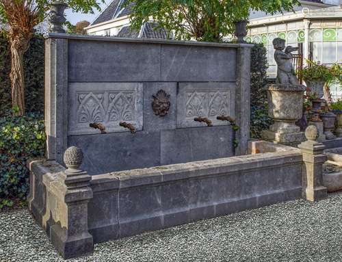 A monumental carved stone wall fountain