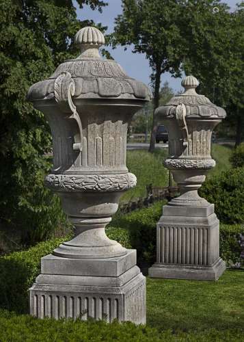 A pair of monumental carved limestone urns-and-covers