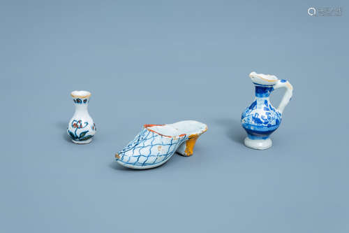 A blue and white slipper, a jug and a polychrome vase with f...