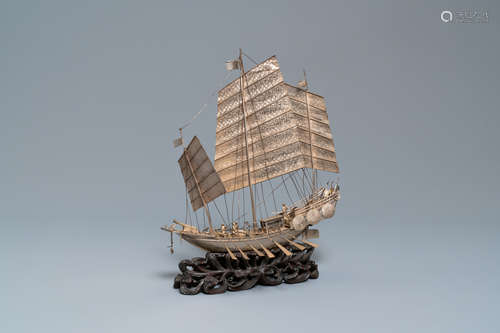 A large Chinese silver model of a junk on carved wooden stan...