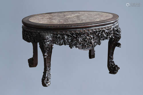 An oval Chinese finely carved wooden table with marble top, ...