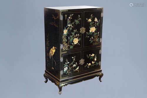 A lacquered Chinese cupboard with birds among blossoming bra...