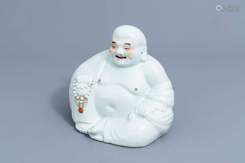 A Chinese white, iron red and gilt porcelain figure of Buddh...