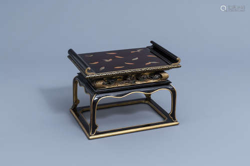 A Japanese gilt and lacquered wooden tray on stand with flor...