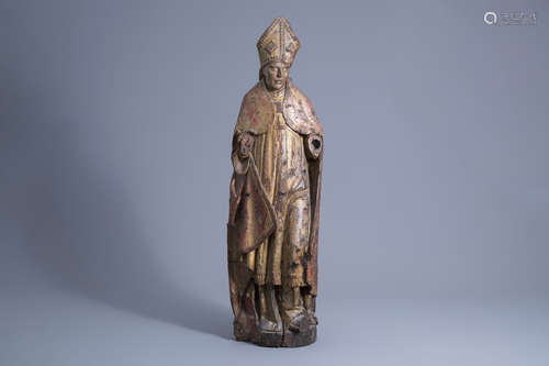 A carved, polychrome painted and gilt wooden figure of a bis...