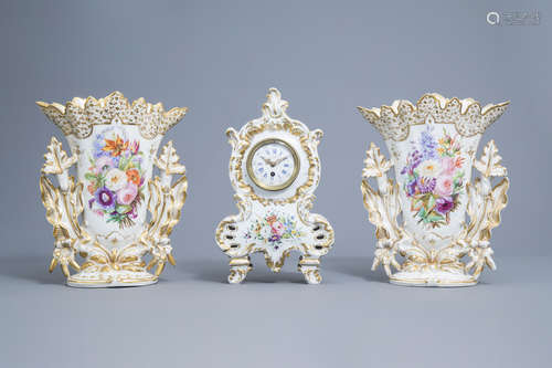 A French mantel clock and a pair of vases in gilt and polych...