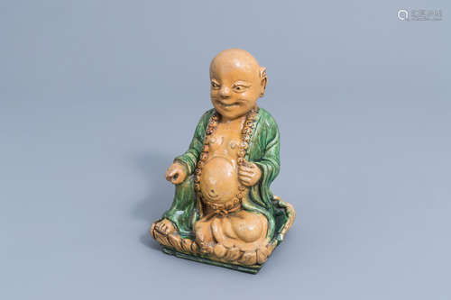 A Chinese sancai-glazed figure of Buddha on a lotus trone, Q...