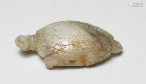 A RARE SMALL PALE GREEN AND RUSSET JADE CARVING OF A TORTOIS...