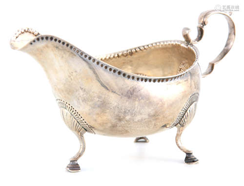 A GEORGE III IRISH SILVER SAUCE BOAT with scroll handle and ...