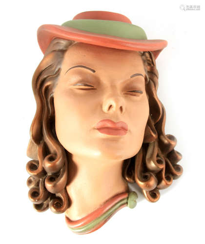 AN ART DECO STYLE POTTERY WALL MASK of a stylised young lady...