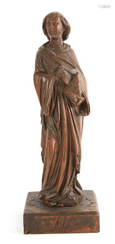 A 16TH CENTURY CARVED OAK FIGURE OF A SAINT holding a bible,...