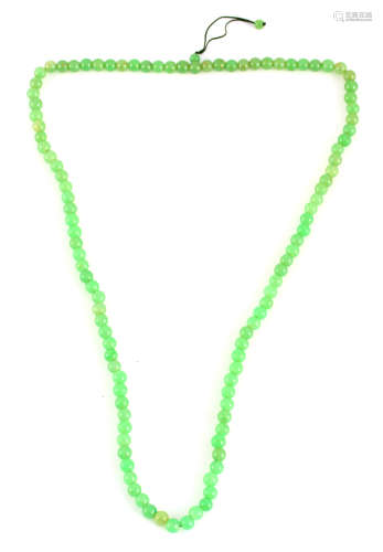 A SET OF THREADED GREEN JADE BEADS 100cm overall