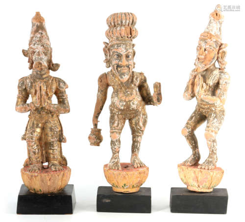 A SET OF THREE EARLY GILT CARVED TIBETAN FIGURES OF STANDING...