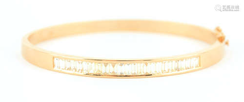 A LADIES 18CT YELLOW AND DIAMOND SET HINGED BANGLE set with ...